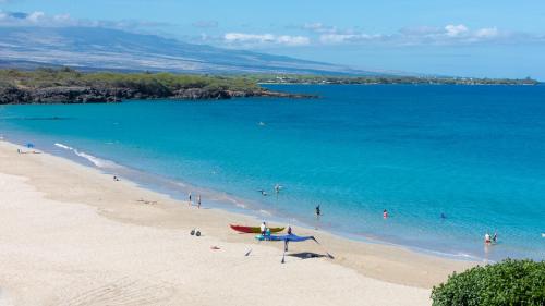 a beach with a group of people in the water at ❤PiH❤ Mauna Kea SunsetsOcean and Golf ViewsOptional Mauna Kea Hotel Privileges in Hapuna Beach