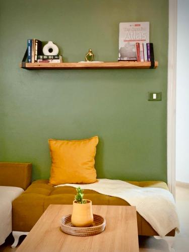 a green room with a bed and a table at Cosy calme appartement à la Marsa in La Marsa