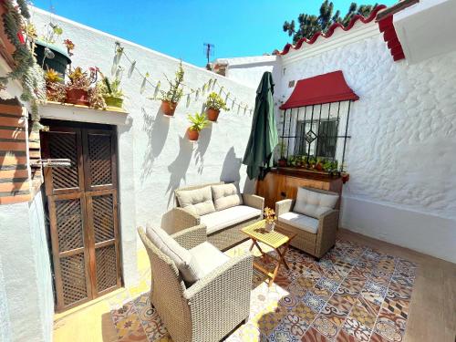 Un patio con sillas y una sombrilla y una mesa. en La Casita Andaluz Marbella 10min Beach Walk, en Marbella