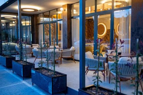 a store front with tables and chairs and windows at Hotel Palazzo in Gornji Vakuf