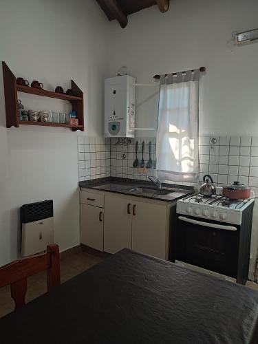 a small kitchen with a stove and a sink at Cabañas azahares del Ayui in Concordia