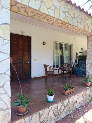 a patio with potted plants and a wooden door at House in Garden in Palermo