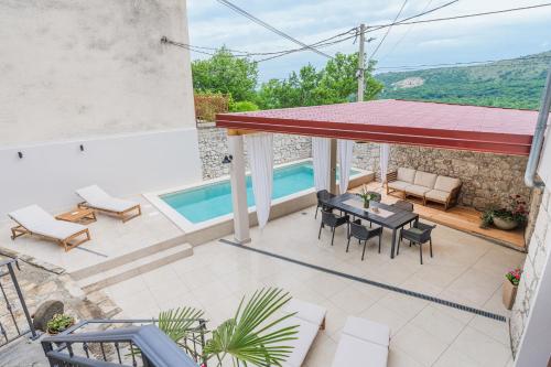 a patio with a table and chairs and a swimming pool at Villa Marisan in Bribir