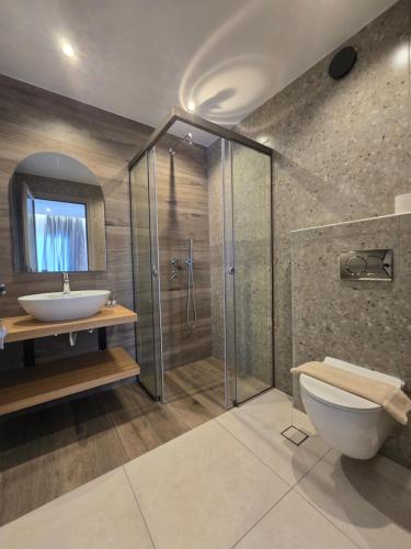 un bagno con doccia, WC e lavandino di White Pebble a Città di Skiathos