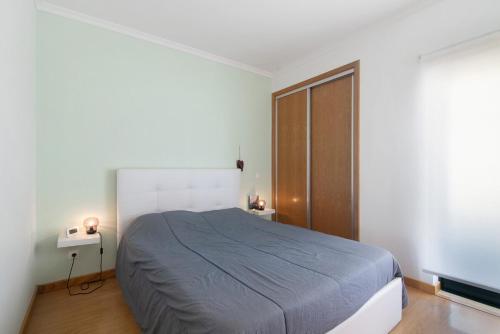 a bedroom with a large bed and a wooden door at Algarve Apartment, Faro - Excellent Location in Faro