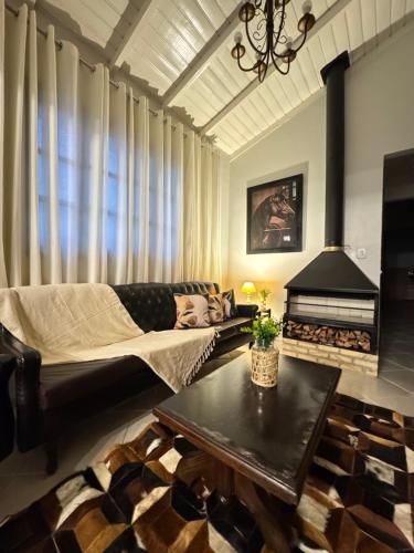 a living room with a couch and a fireplace at RJ Sitio Refugio da Serra fazendinha in Rancho Queimado