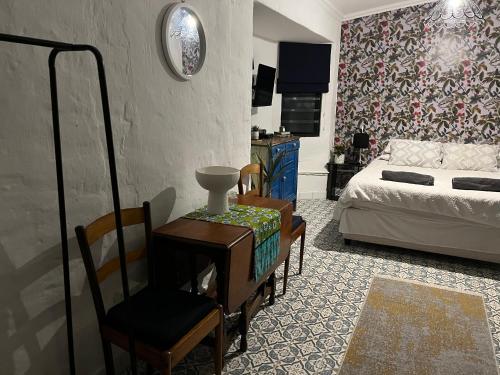 a living room with a bed and a table and chairs at Studio at 142 in Durban