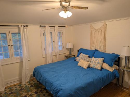 a blue bed in a bedroom with a ceiling fan at Luxury at the 1912 Sharp Mansion in Colorado Springs