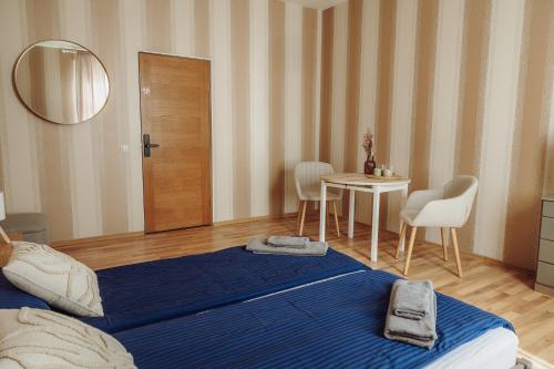 a bedroom with a bed and a table with chairs at Telegrāfs Hotel in Ventspils