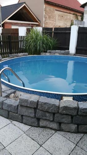 a swimming pool with a stone wall around it at Apartmán Maria in Litoměřice