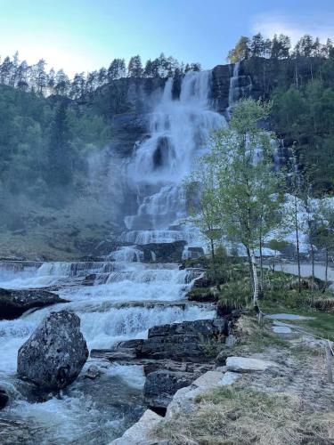 a waterfall in the middle of a river at Helgatunlia - Leilighet 2 in Vossevangen