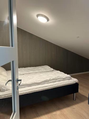 a small bed in a room with a wall at Helgatunlia - Leilighet 2 in Vossevangen