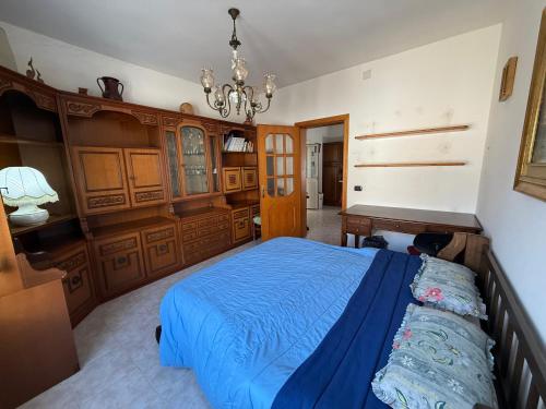 a bedroom with a blue bed and a chandelier at Casa Vacanze Anita in Carbonia