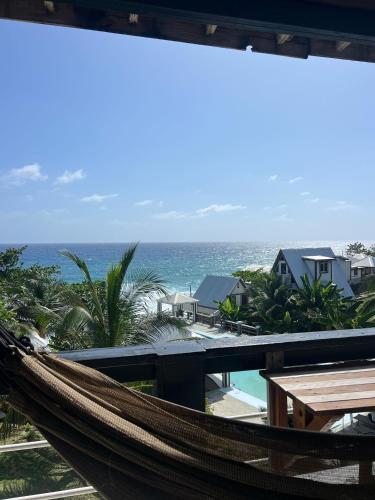 a hammock on a balcony with a view of the ocean at The Sea Cliff Hotel Resort & Spa in Port Antonio