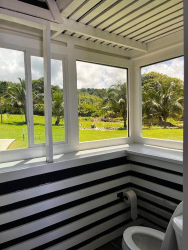 a bathroom with two windows and a white toilet at The Sea Cliff Hotel Resort & Spa in Port Antonio
