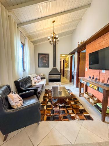 a living room with a couch and a fireplace at RJ Sitio Refugio da Serra fazendinha in Rancho Queimado