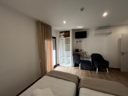 ein Wohnzimmer mit einer Couch und einem Schreibtisch in einem Zimmer in der Unterkunft Solar de São Pedro in Monção