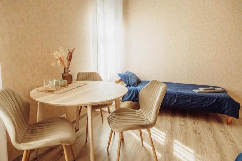 a bedroom with a bed and a table and chairs at Telegrāfs Hotel in Ventspils