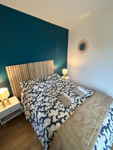 a bedroom with a bed with a blue wall at Gîte Cosy - 90m2 - T4 - Climatisé - Tout équipé in Retournac