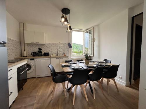 a kitchen and dining room with a table and chairs at Gîte Cosy - 90m2 - T4 - Climatisé - Tout équipé in Retournac