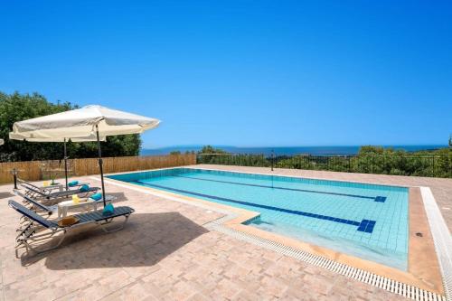 a swimming pool with an umbrella and a chair and an umbrella at Villa Kismet by Villa Plus in Mousata