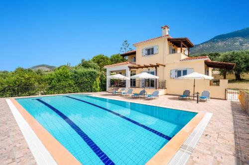 a villa with a swimming pool and a house at Villa Kismet by Villa Plus in Mousata