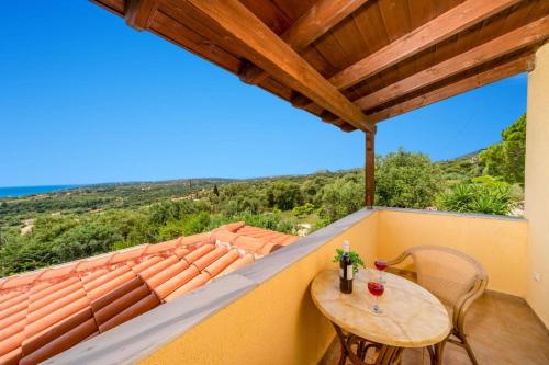 a table and chairs on a balcony with a view at Villa Kismet by Villa Plus in Mousata