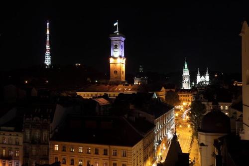 a view of a city at night with a clock tower at Lux Apart Lviv apartments in Lviv