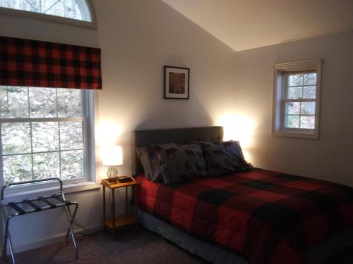 a bedroom with a bed and two windows at Mcleod Cottage in Norway