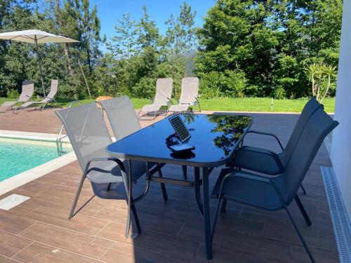 a blue table and chairs next to a pool at Casas Peralta - Outeiro in Arouca