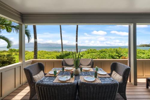 a table on a porch with a view of the ocean at Kahana Village 31 · KHV 31 Spacious Direct Oceanfront 3BD Condo in Kahana