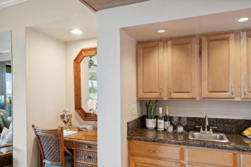 a kitchen with wooden cabinets and a sink at Kahana Village 31 · KHV 31 Spacious Direct Oceanfront 3BD Condo in Kahana