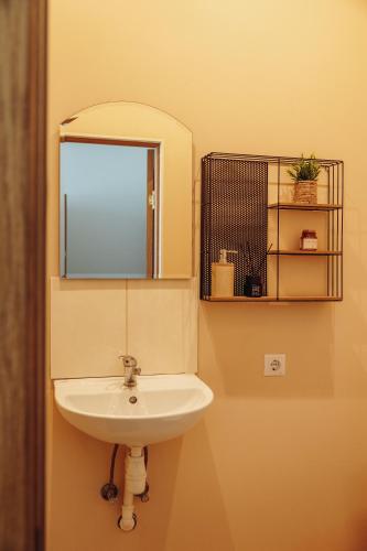 a bathroom with a sink and a mirror at Telegrāfs Hotel in Ventspils