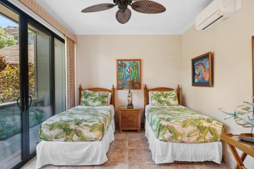 two beds in a room with a window at Kahana Village 31 · KHV 31 Spacious Direct Oceanfront 3BD Condo in Kahana