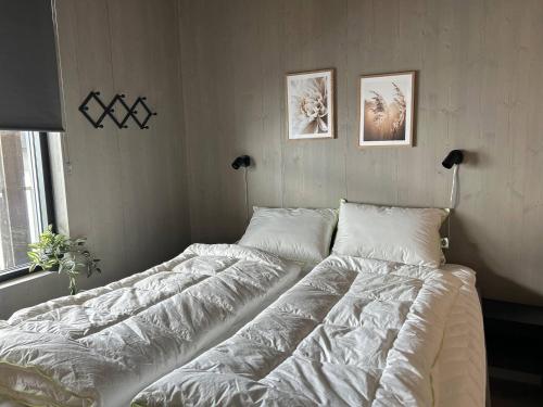 a bedroom with a large bed with white sheets at Helgatunlia - Leilighet 6 in Vossevangen