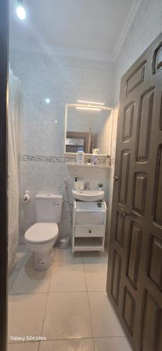 a bathroom with a toilet and a sink and a door at Dar Tetuan 4 You III in Tétouan