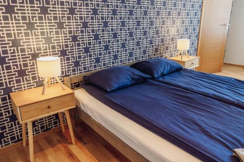 a bedroom with a bed and two lamps on tables at Telegrāfs Hotel in Ventspils
