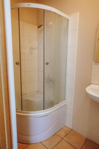 a shower with a glass door in a bathroom at Telegrāfs Hotel in Ventspils
