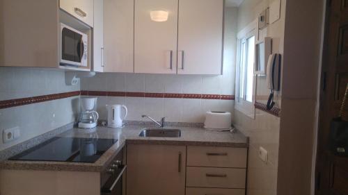 a small kitchen with white cabinets and a sink at Marbella Apartment in Marbella