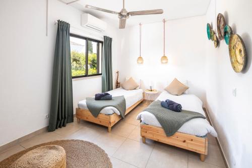 a bedroom with two beds and a window at Carvoeiro -Spacious 2 bedroom appartment with pool - Monte Dourado in Carvoeiro