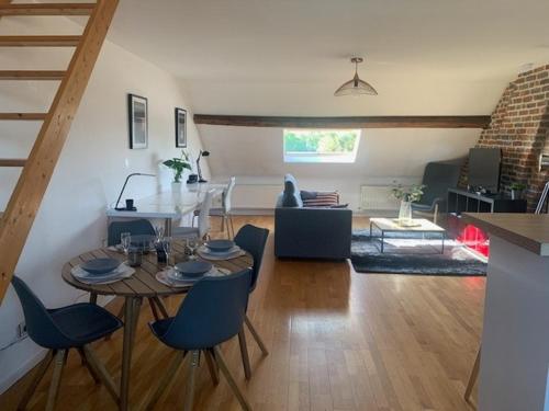 une salle à manger et un salon avec une table et des chaises dans l'établissement Superbe Appartement Cosy, à Anzin