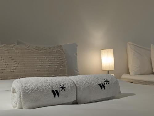 a bed with two towels and a lamp on it at Modern Lofts in Plaza De La Independencia in Panama City