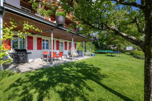 a patio with chairs and a grill on a house at Chalet Gaertli in Thun