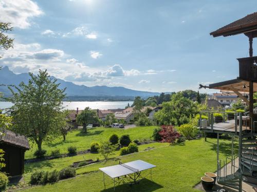 a picnic table on a lawn with a view of the water at Chalet Gaertli in Thun