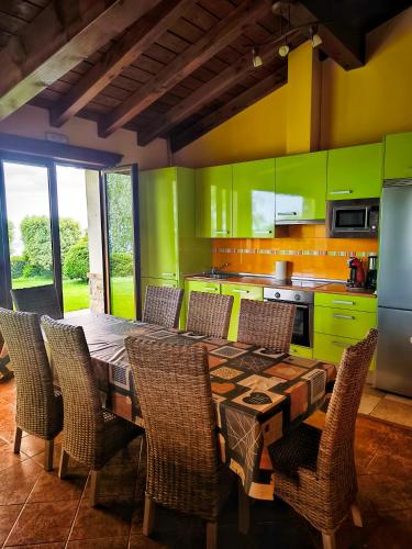 a kitchen with a table and chairs and green cabinets at Izetaerdi - Casa con encanto y vistas únicas in Zarautz
