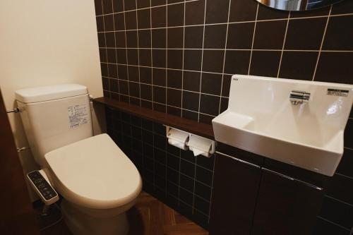 a bathroom with a white toilet and a sink at THE NEST 森の灯 MUNAKATA by ritomaru in Munakata