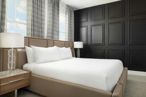 a bedroom with a large white bed and a window at Villatel Orlando Resort, Apartments by Marriott Bonvoy in Orlando