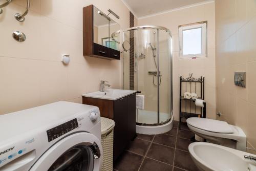 a bathroom with a washing machine and a sink at Apartment Iva in Šilo