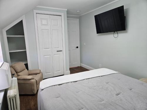 a bedroom with a bed and a chair and a television at Middletown Modern Townhouse in Middletown