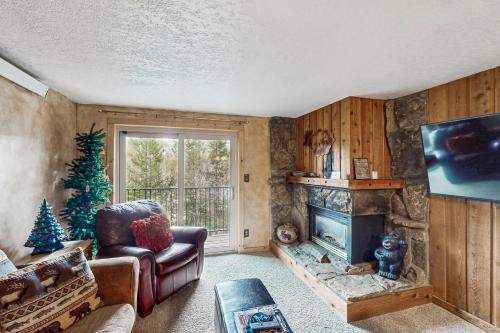 a living room with a fireplace and a christmas tree at Beaver Village in Winter Park